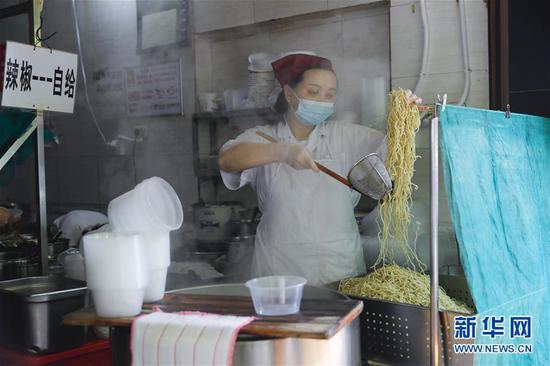 4月22日，武漢市糧道街的家陽“趙師傅”天天紅油熱干面店廚師在制作熱干面。新華社記者 沈伯韓 攝