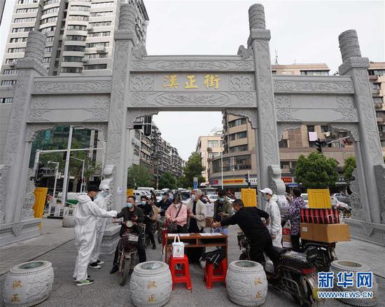  4月16日，進(jìn)出武漢漢正街步行街的人員在掃描健康碼。新華社記者 王毓國 攝